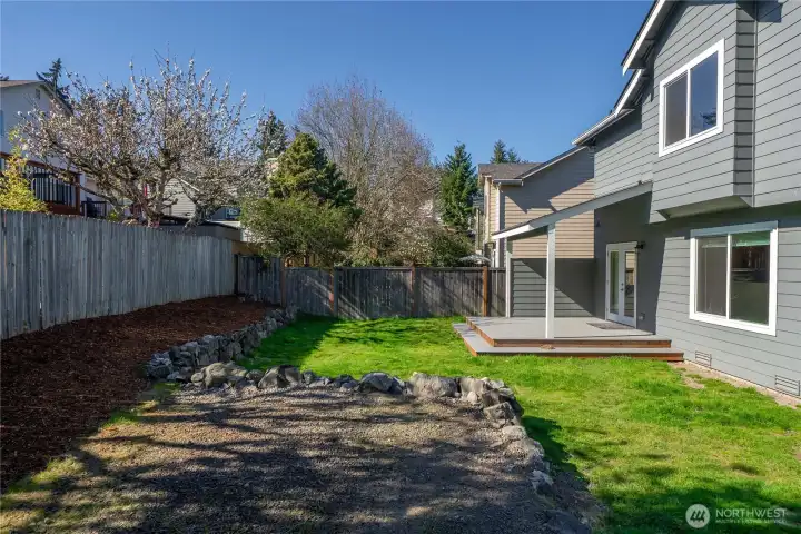 Great fenced back yard with grassy area and gravel area for parking