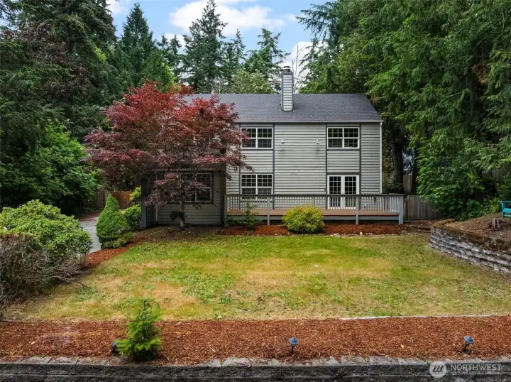 Welcoming front exterior with mature landscaping, an expansive lawn, and a peaceful setting surrounded by established trees. Welcoming front exterior with mature landscaping, an expansive lawn, and a peaceful setting surrounded by established trees.