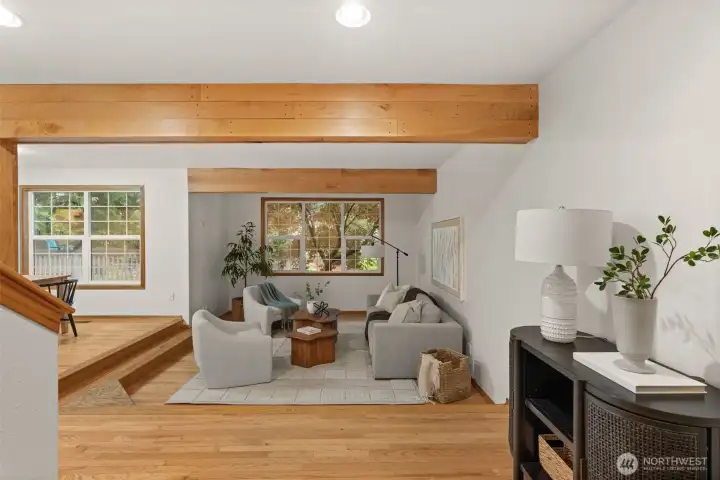 Spacious living room offers exposed wood beams, abundant natural light, and views of the surrounding greenery. Spacious living room offers exposed wood beams, abundant natural light, and views of the surrounding greenery.