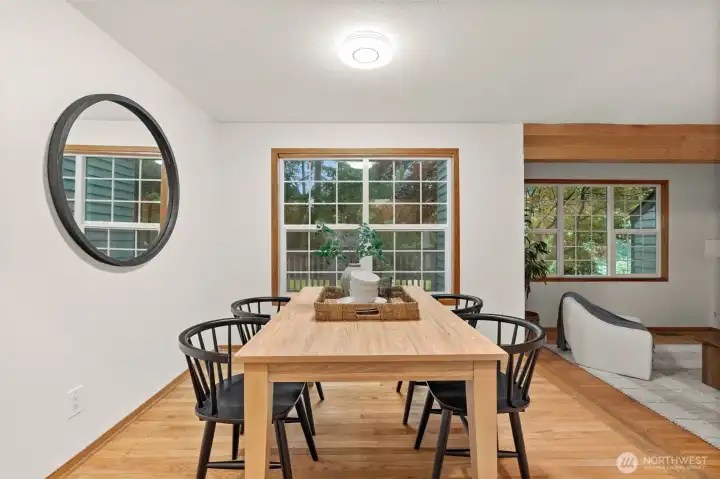 Large windows bring natural light into the dining area while showcasing views of the outdoor setting. Large windows bring natural light into the dining area while showcasing views of the outdoor setting.