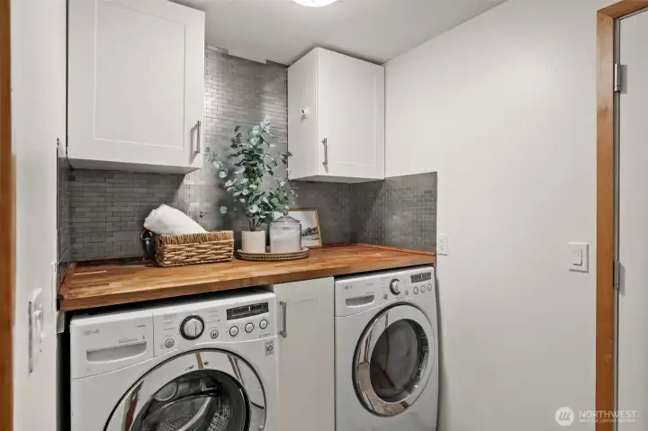 Dedicated laundry area features built-in cabinetry, countertop workspace, and additional storage. Dedicated laundry area features built-in cabinetry, countertop workspace, and additional storage.