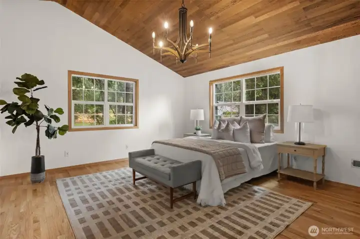 Vaulted wood ceilings and large windows enhance the character and openness of the primary bedroom. Vaulted wood ceilings and large windows enhance the character and openness of the primary bedroom.