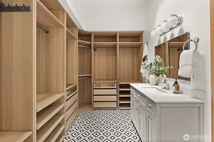 Custom walk-in closet features extensive built-in organization, shelving, drawers, and a dedicated vanity area. Custom walk-in closet features extensive built-in organization, shelving, drawers, and a dedicated vanity area.