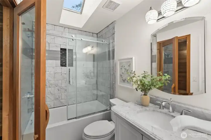 Bathroom combines practical design with updated finishes, including a tile surround and modern vanity. Bathroom combines practical design with updated finishes, including a tile surround and modern vanity.