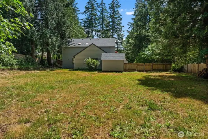 Fully fenced backyard provides a blend of privacy, open space, and natural surroundings. Fully fenced backyard provides a blend of privacy, open space, and natural surroundings.