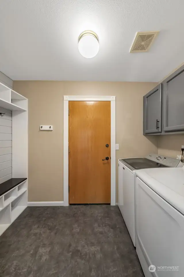 Utility room with custom built-in and cabinetryt - enter and exit the garage.