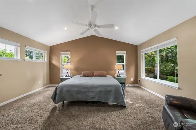 Upstairs primary bedroom with ceiling fan and lots of natural light. Large window looks out to the private backyard.