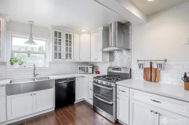 Professional stove and sink with cabinet space.