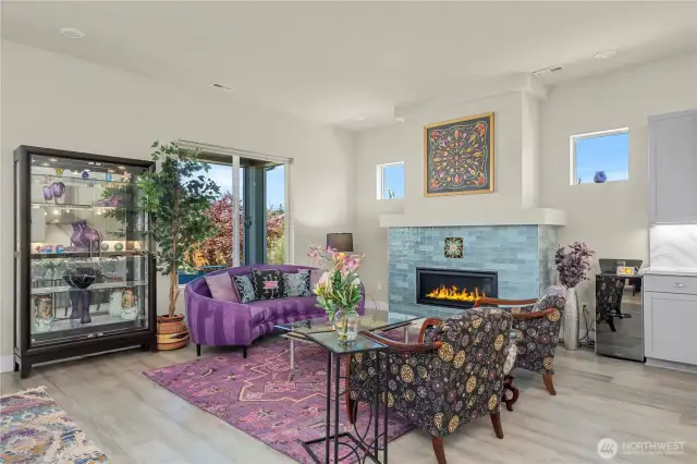Custom tiled fireplace with mantle creates a lovely place to gather. Large windows allow generous light and welcome in the beautiful backyard vistas.