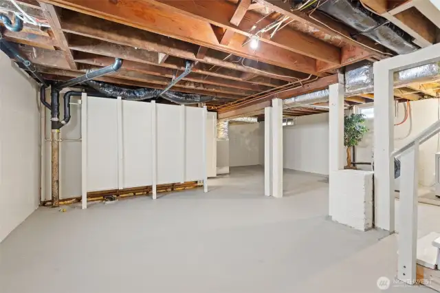 View of the basement. Behind the white wall is an extra room with ample closet space. Currently set up as a home office. Plumbing available in the basement for future expansion or potential Primary Suite.