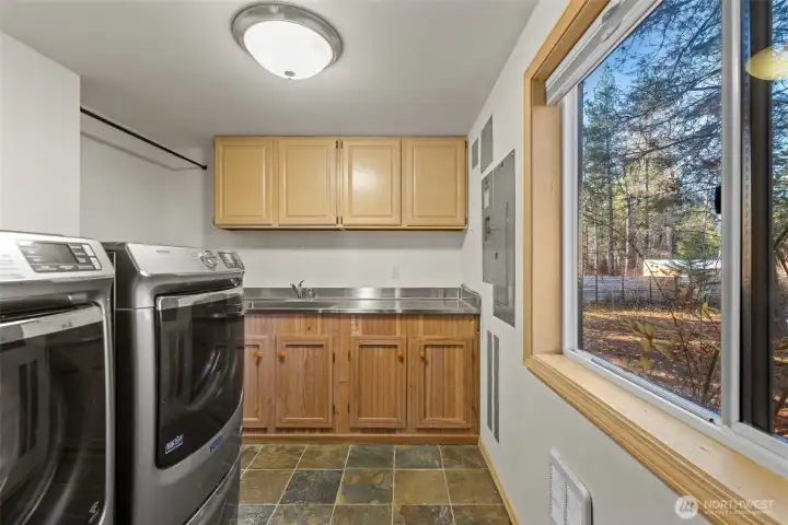 Spacious laundry room with sink and newer appliances.