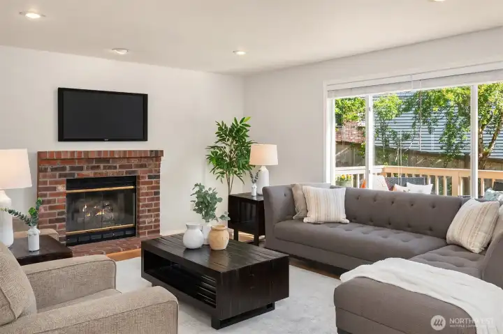 Spacious Family Room Featuring a Gas Fireplace, Hardwood Floors and Large Windows Streaming Natural Sunlight