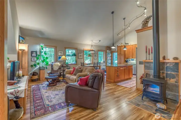 Upper level open floor plan welcomes you to a cozy warmth with hearthstone wood stove and natural wood finish throughout. Vaulted ceilings and large windows give you a feeling of space and natural light energy.