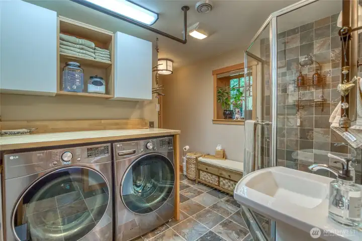 Main level bathroom with laundry. Custom tiled shower w/glass surround. Plenty of storage.