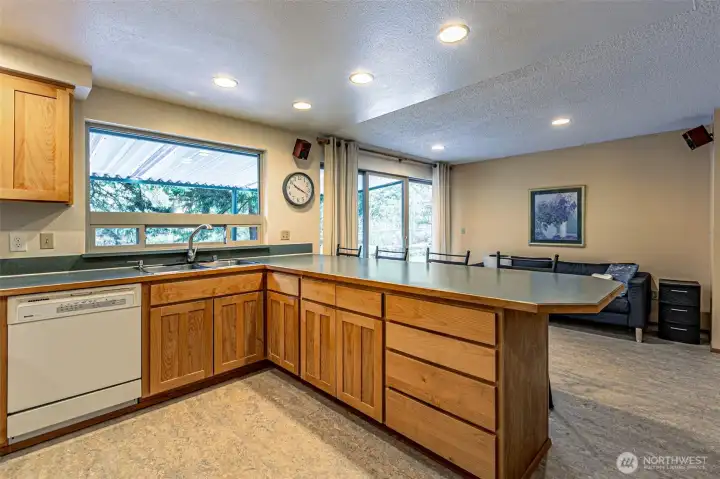 Open concept living with kitchen with four seat eating bar. The dining room opens to the covered patio.