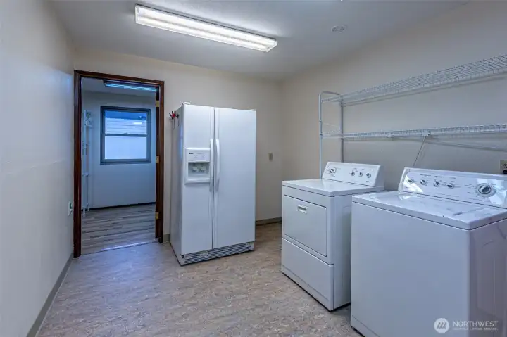 The spacious laundry room includes a second refrigerator