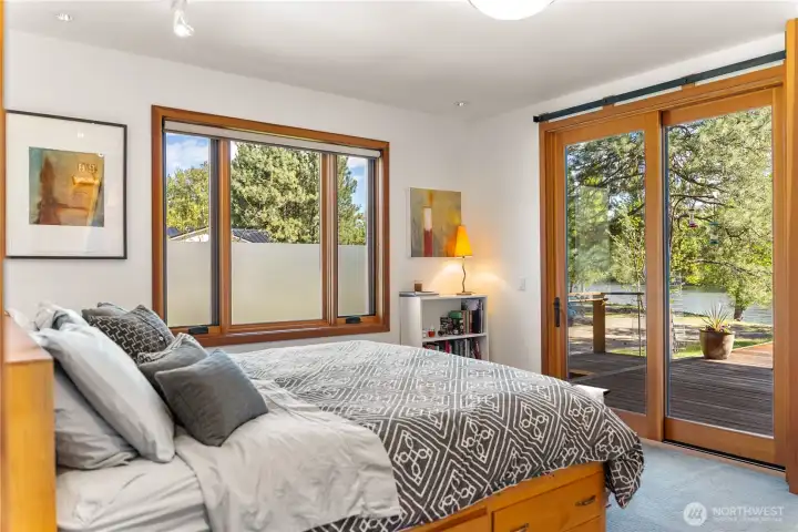 Primary bedroom with large sliding glass door with direct access to the deck and views of the river.