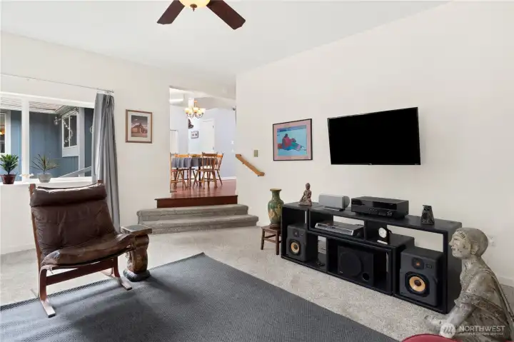 Family room is three steps down and on the same level as the garage. The TV does not convey, but the wall bracket can stay or be removed.