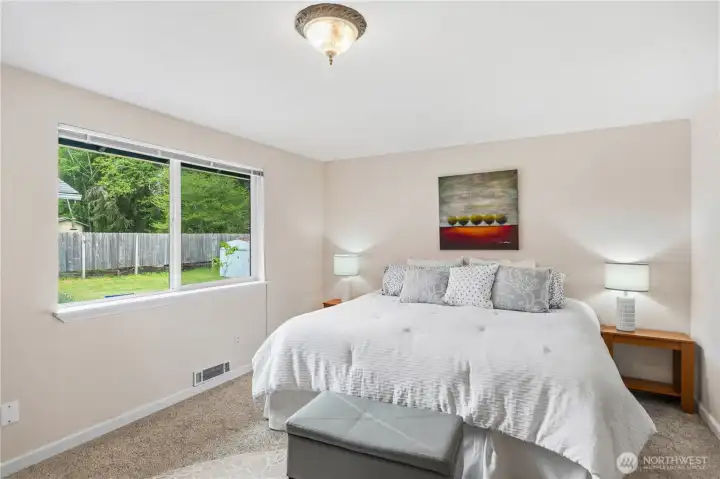 Primary bedroom is a large room. This is a king-sized bed. Look out to the back yard from this room.