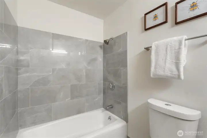 Beautifully tile bath/shower in guest bathroom.,