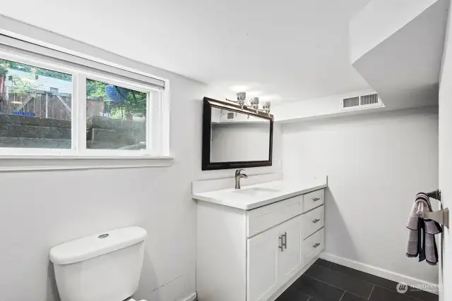 Downstairs bathroom's new vanity lighting, mirror, sink, faucet, countertop and storage cabinet.