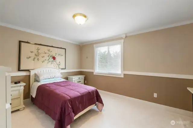 One of three guest bedrooms is spacious and offers a built-in desk.