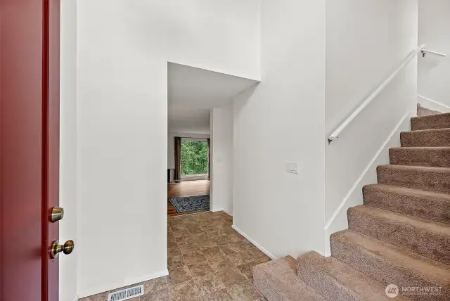 The entryway features a convenient coat closet for guests and soaring ceilings with windows that fill the space with natural light