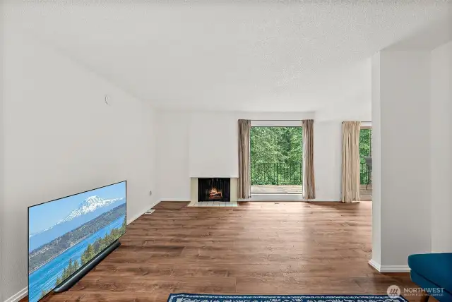 Spacious living room featuring recently updated LVP flooring and a cozy fireplace—perfect for relaxing or entertaining