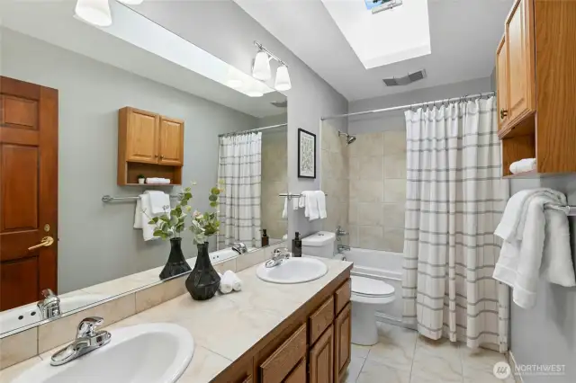 Shared hall bath with dual sinks & jetted shower/tub.