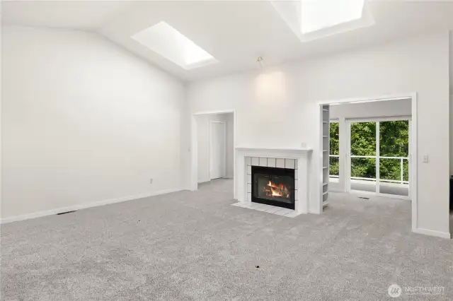 Built in bookshelves on the sides of the fireplace lead to a sunny space.
