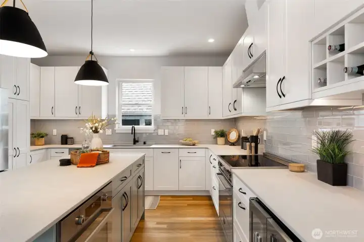 Beautiful kitchen with Bertazonni appliances and beautiful surfaces. Note integrated dishwasher, two ovens and wine/beverage fridge.