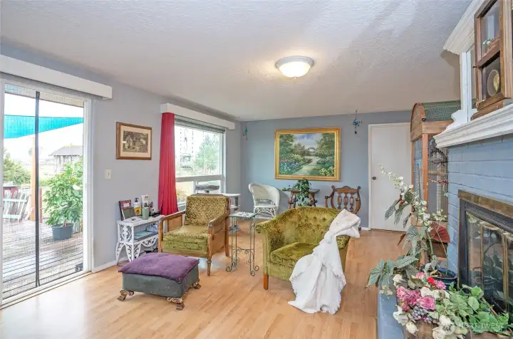 Another view of the living room and wood burning fireplace. Floor is newer laminate.