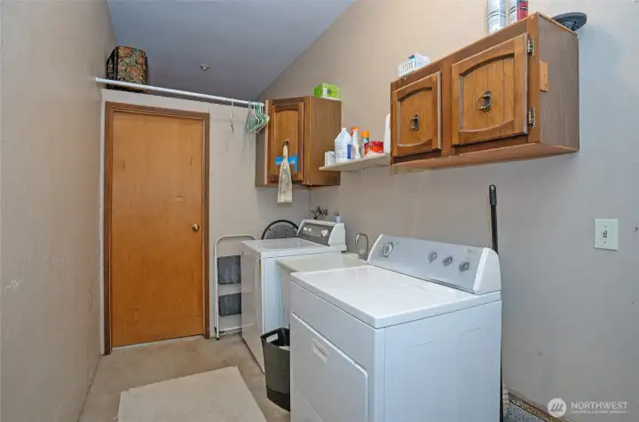 Laundry room is off the family room. A door leads to the back yard. The door in the background is the large canning/pantry room