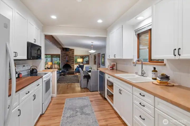 The open galley kitchen has a window over the sink, yards of countertops and abundant cabinetry!