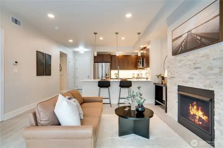 Welcome to your new home! This modern living room seamlessly opens to the kitchen, creating a bright, open-concept space perfect for entertaining and everyday living.