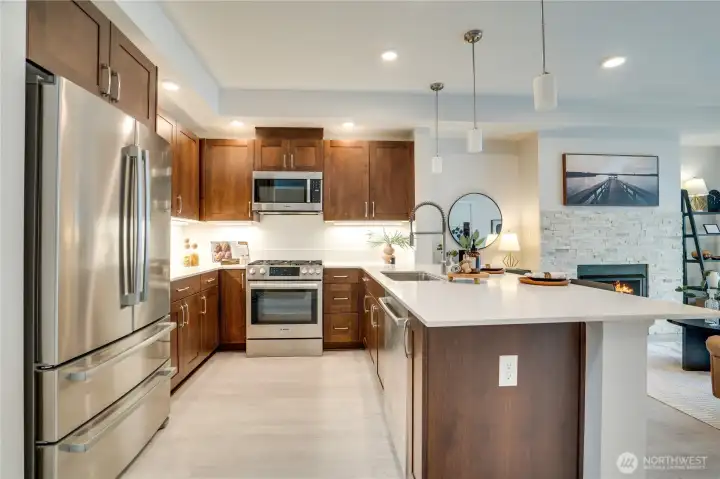 Stylish kitchen featuring quartz countertops, stainless steel appliances, and a gas range for a sleek, modern finish.
