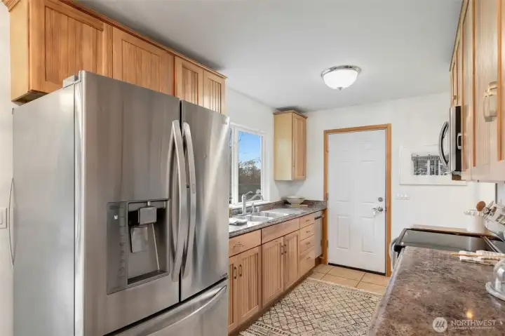 Roomy galley style kitchen with large window facing the backyard.