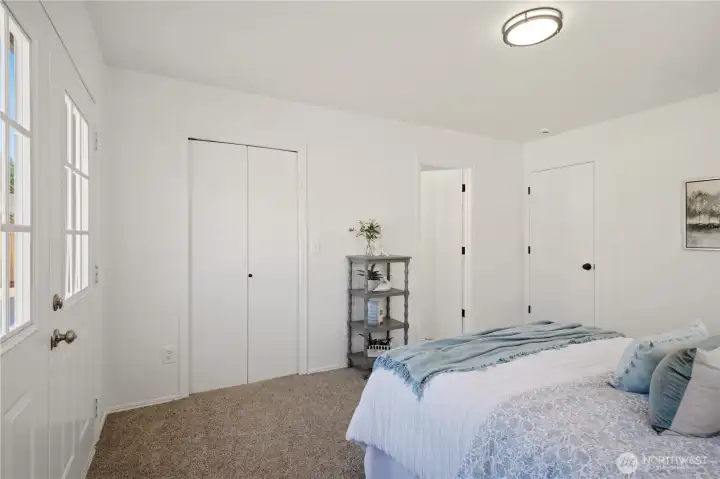 The double doors just ahead lead to the primary suite's walk in closet. To the right is the door to the primary suite's private full bath.