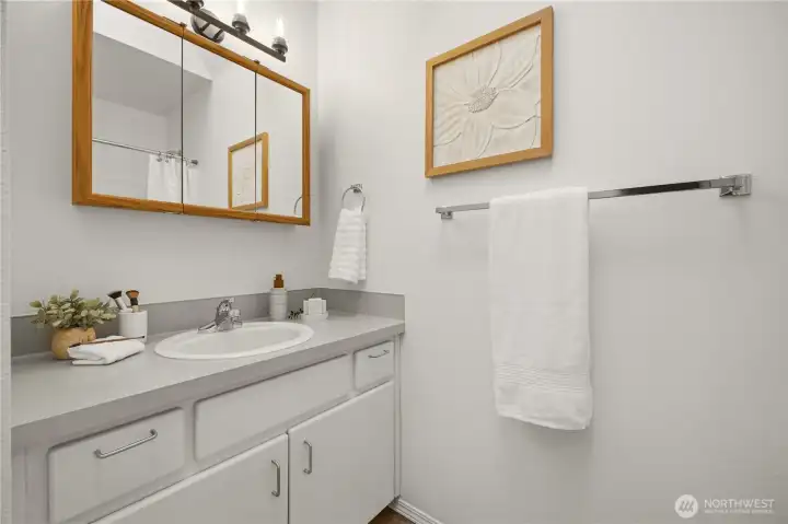 The main bathroom of the home is shown here. It features a new light fixture and new flooring.