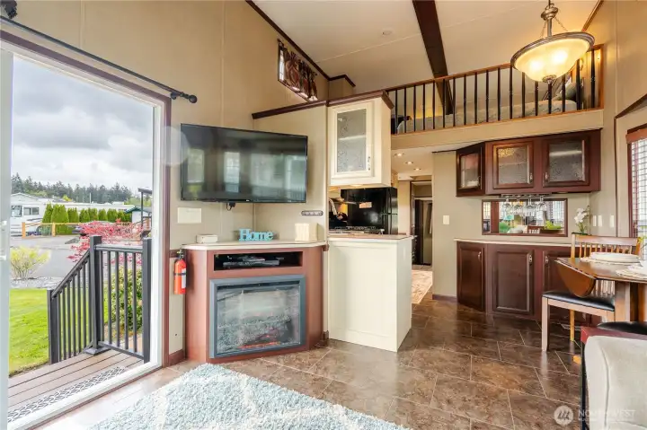 Standing in the living room and looking back toward the kitchen, you see the cozy fireplace that will keep you warm on chilly nights.