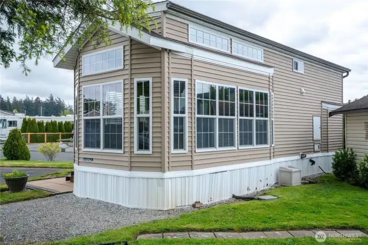 Outside, this well maintained park model sits on a grassy lot with ample parking.