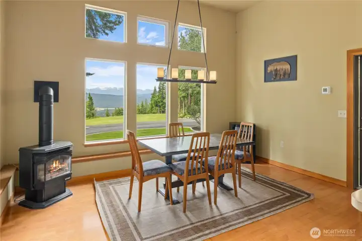 Dining area with breathtaking views and a free standing propane stove that creates a warm, welcoming atmosphere. Wine Cooler stays!