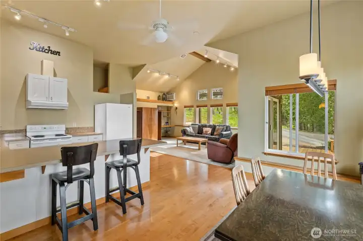 This angle highlights the seamless flow between the kitchen, dining, and living spaces, accented by hardwood floors.