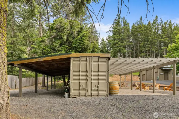 A unique upcycled container offers covered storage, a custom bar area, and a patio designed for entertaining. Lean-to for extra storage is 14'x40'.