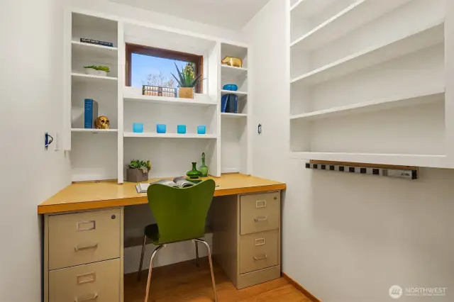 This cute office just as you enter from the garage, has a door for privacy, and a nice window.  The shelves on the right have a secret latch that allows them to swing open revealing a huge storage nook.