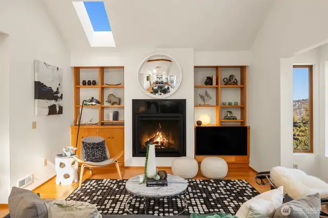 Wood floors and built-ins pop against white walls, flanking the gas fireplace.  A skylight adds to the already abundant natural light in this awesome space.