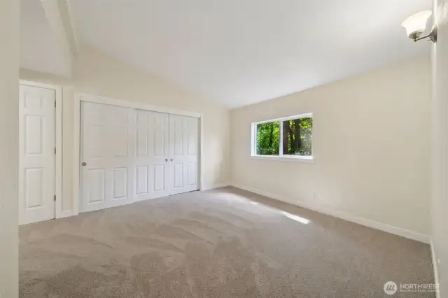 Primary bedroom with lots of closet space & vaulted ceilings.