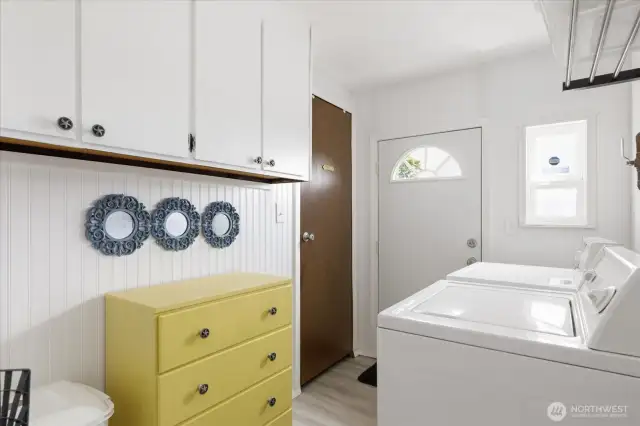 Laundry room with door to the outside so you can throw your work clothes right in the wash. The storage closet and cabinetry provide more storage space.