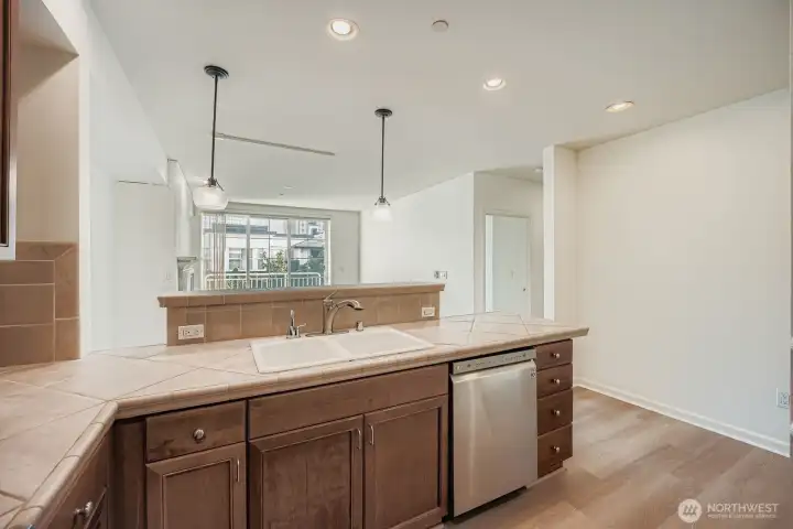 Functional layout with breakfast bar, pendant lighting, and open flow to the living room.