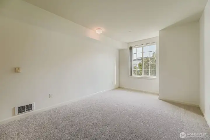 Large primary suite with natural light and neutral finishes.